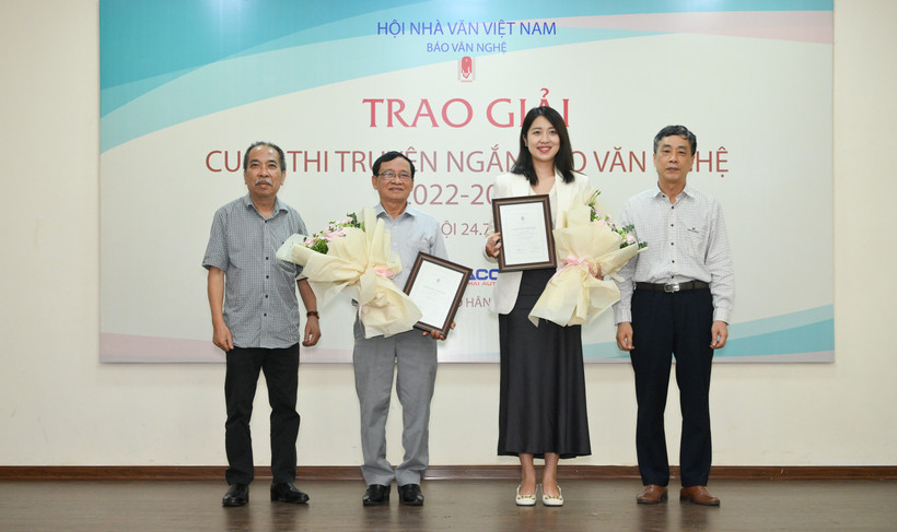 Hai tác giả đạt giải Nhì, Vũ Ngọc Thư (thứ hai, từ trái sang) và Ngô Tú Ngân (thứ ba, từ trái sang), nhận Chứng nhận và hoa chúc mừng từ Chủ tịch Hội Nhà văn Việt Nam Nguyễn Quang Thiều và Chủ tịch Hội đồng Giám khảo Nguyễn Bình Phương.