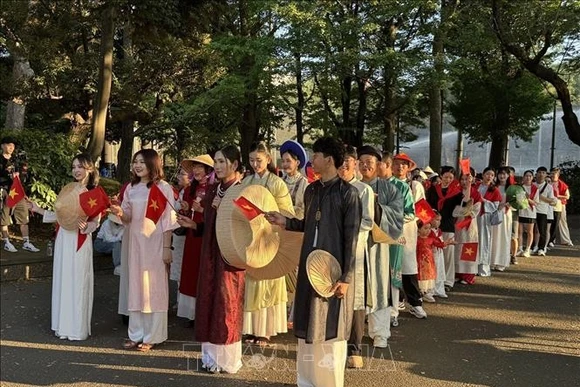 Hơn 200 người Việt và bạn bè Nhật Bản đi bộ trong trang phục áo dài truyền thống của Việt Nam. (Ảnh: TTXVN)