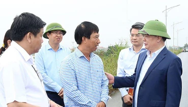 Đồng chí Đinh Tiến Dũng trò chuyện với người dân có đất nằm trong dự án Vành đai 4-Vùng Thủ đô trên địa bàn huyện Hoài Đức.