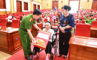 Đại tá Đỗ Tiến Thùy, Phó Giám đốc Công an tỉnh Tuyên Quang tặng quà Mẹ Việt Nam Anh hùng, mẹ liệt sĩ tham gia lấy mẫu.