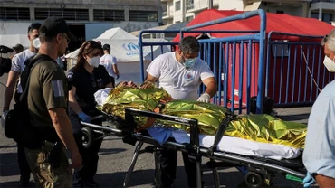 Nhân viên cứu nạn đưa người di cư lên xe cứu thương. (Ảnh: Reuters)