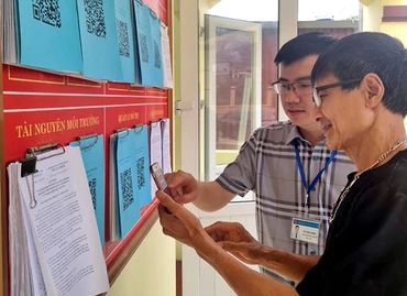 Hướng dẫn nhân dân quét mã QR để tra cứu thủ tục hành chính tại phường Sông Cầu, thành phố Bắc Kạn. (Ảnh: ĐĂNG BÁCH)