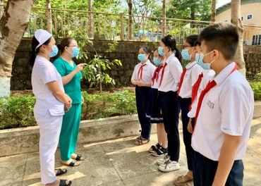Nhân viên y tế phường Hoa Lư (TP. Pleiku, Gia Lai) tuyên truyền về phòng, chống dịch Covid-19 cho các em học sinh. (Ảnh: Như Nguyện) 