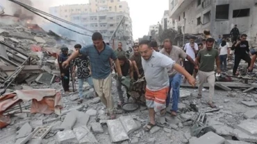 Chuyển thi thể nạn nhân sau các cuộc không kích của Israel xuống Dải Gaza. Ảnh: IRNA/TTXVN