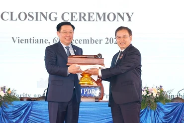 Chủ tịch Quốc hội Vương Đình Huệ nhận búa đảm nhận chức Chủ tịch Hội nghị cấp cao Quốc hội ba nước CLV lần thứ hai từ Chủ tịch Quốc hội nước Lào Saysomphone Phomvihane. (Ảnh: TTXVN)