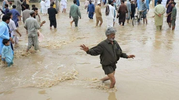 Người dân di chuyển trên con đường bị ngập tại Charsadda, Pakistan. (Ảnh: Reuters)