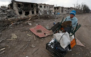 Người phụ nữ đẩy xe chở đồ đạc dọc theo một tuyến đường tại vùng Donetsk, Ukraine, ngày 15/3. (Ảnh: Reuters)