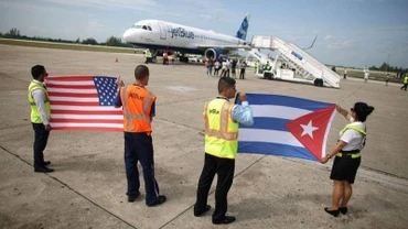 Nhân viên mặt đất cầm cờ Mỹ và Cuba đón chuyến bay thương mại đầu tiên giữa hai nước trong hơn 50 năm, tại Sân bay quốc tế Abel Santamaria của Cuba, ngày 31/8/2016. (Ảnh: Reuters)
