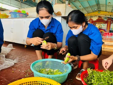 Các tình nguyện viên của Đoàn Thanh niên Thị trấn Chư Ty (huyện Đức Cơ) nấu ăn miễn phí cho các sĩ tử. (Ảnh Phan Lài) 