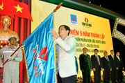 Ông Trần Tuấn Anh, Thứ trưởng Công Thương gắn Huân chương Lao động hạng Nhì lên lá cờ truyền thống của PVCFC.