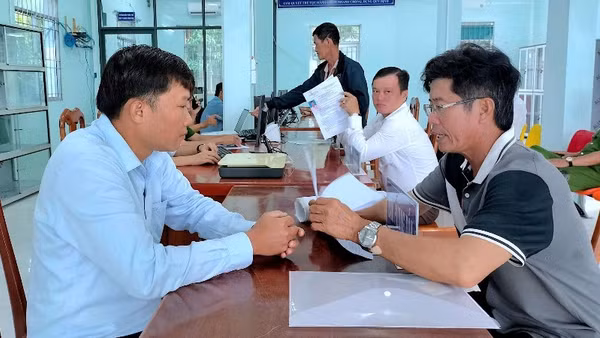 Cán bộ xã Đất Mũi (Cà Mau) hướng dẫn người dân thực hiện các thủ tục hành chính.
