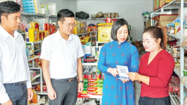 Các cán bộ của Co-opBank Phú Thọ hướng dẫn hộ kinh doanh tiếp cận dịch vụ số của ngân hàng.