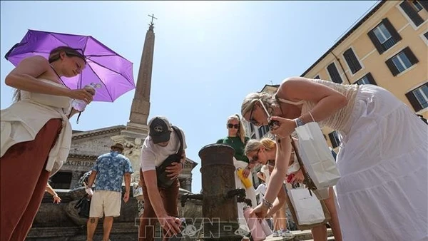 Người dân lấy nước uống để giải nhiệt trong ngày nắng nóng tại Rome, Italy. (Ảnh: THX/TTXVN)