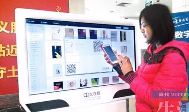 Độc giả tìm và tải sách điện tử thông qua mã QR ở một lễ hội sách điện tử ở Quảng Tây, Trung Quốc. (Ảnh: Tô Minh - Hữu Hưng)