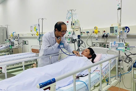 Phó Giáo sư, Tiến sĩ, bác sĩ Phạm Văn Quang, Trưởng khoa Hồi sức tích cực-Chống độc, Bệnh viện Nhi đồng 1 khám bệnh nhi nữ 12 tuổi từ Trà Vinh. (Ảnh: CHI MAI)