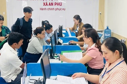 Cán bộ, viên chức xã An Phú hướng dẫn thủ tục hành chính cho người dân vùng biển Quảng Ngãi. (Ảnh ĐÔNG HUYỀN)