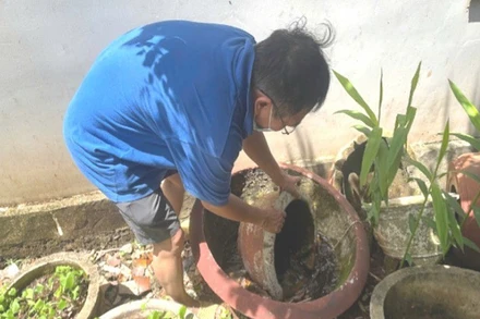 Người dân phường Buôn Ma Thuột, tỉnh Đắk Lắk chủ động lật úp các dụng cụ chứa nước để phòng, chống sốt xuất huyết.
