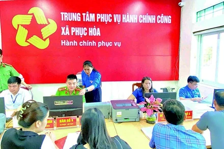 Cán bộ Trung tâm Phục vụ hành chính công xã Phục Hòa, tỉnh Cao Bằng hỗ trợ người dân thực hiện thủ tục hành chính. (Ảnh: TUYẾT TRINH)