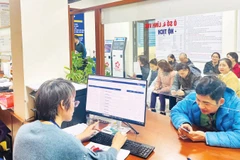 Người dân làm thủ tục đăng ký hộ tịch tại bộ phận một cửa phường Định Công, Hà Nội.