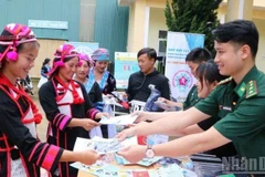 Phát tờ rơi tuyên truyền nhằm nâng cao nhận thức về phòng, chống mua bán người ở biên giới Lai Châu.(Ảnh: Bộ đội Biên phòng)