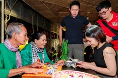 Vợ chồng nghệ nhân Trương Thị Chiều hướng dẫn du khách trải nghiệm làm bánh dân gian.