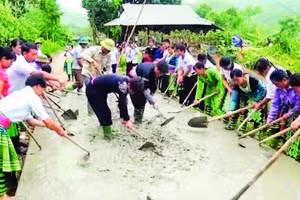 Đồng bào H’Mông xã Hưng Khánh tham gia đổ bê-tông làm đường giao thông nông thôn.