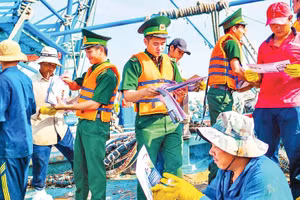 Bộ đội Biên phòng Thành phố Hồ Chí Minh phát tờ rơi tuyên truyền cho ngư dân trên tàu cá.