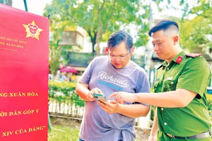 Công an phường Xuân Hòa hướng dẫn người dân thao tác, sử dụng các tiện ích trên Ứng dụng VNeID. 