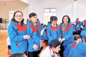 Bà Nguyễn Thị Thu Hà (người ngoài cùng, bên phải, hàng đứng) mặc áo ấm cho học sinh ở Trung tâm Nuôi dạy trẻ khuyết tật Võ Hồng Sơn.