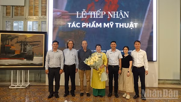 Các đại biểu chụp ảnh lưu niệm tại lễ tiếp nhận tác phẩm mỹ thuật. (Ảnh: Linh Bảo).