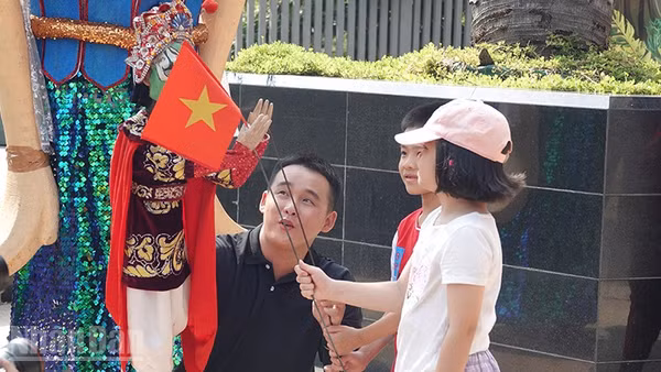 Các em nhỏ thích thú khi được làm quen với các nhân vật rối. (Ảnh: Linh Bảo).