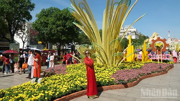 Người dân đến chụp ảnh tại Đường hoa Nguyễn Huệ từ sớm trong ngày mùng 1 Tết. (Ảnh: Linh Bảo)