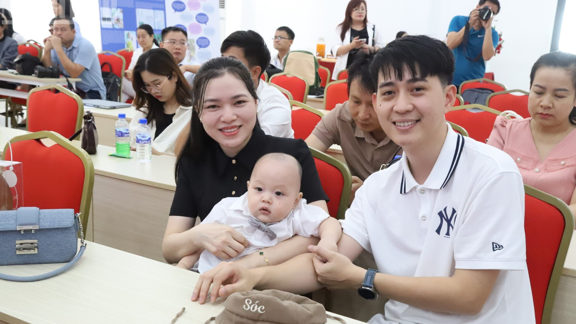 Một cặp vợ chồng hạnh phúc và phấn khởi đưa con tới dự lễ kỷ niệm. img-2334-8311.jpg