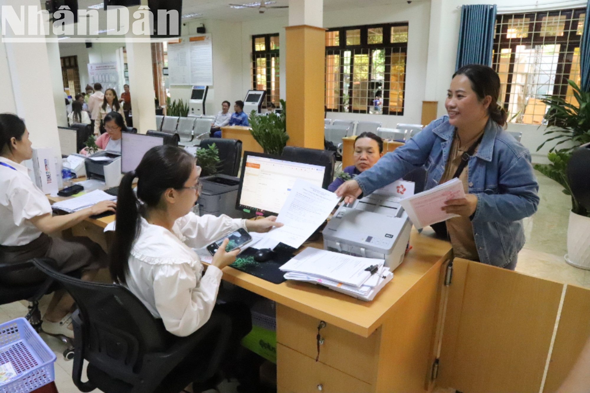 Một người phụ nữ tươi cười khi nộp hồ sơ. img-0836-2325.jpg