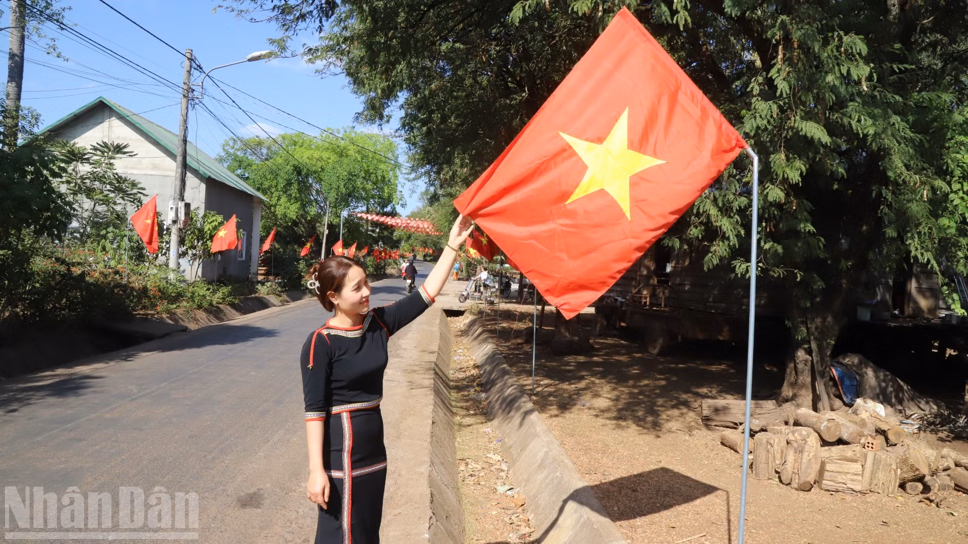 Bí thư Chi bộ buôn Tuôr, xã Hòa Phú H'Lin H'Đớt treo cờ Tổ quốc hướng về Đại hội XIV của Đảng.