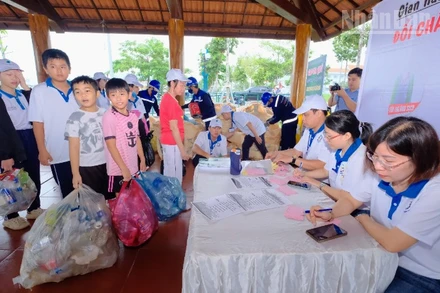 Các em học sinh trên địa bàn phường Bình Phước thu gom chai nhựa đến điểm đổi nhận quà.