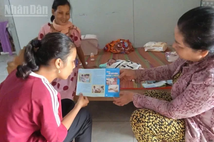 Chị Điểu Thị Thủy (bìa trái) hướng dẫn nhân dân chăm sóc sức khỏe sinh sản tại gia đình.