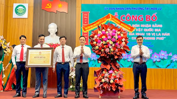 Đại diện lãnh đạo phường Tây Hoa Lư đón nhận Bằng công nhận Bảo vật quốc gia "Bộ tranh khắc ma nhai 18 vị La Hán động Liên Hoa, chùa Phong Phú”. (Ảnh: YẾN TRINH)