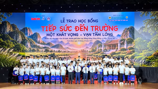 Các đại biểu trao học bổng cho các em học sinh tại buổi lễ. (Ảnh: YẾN TRINH)