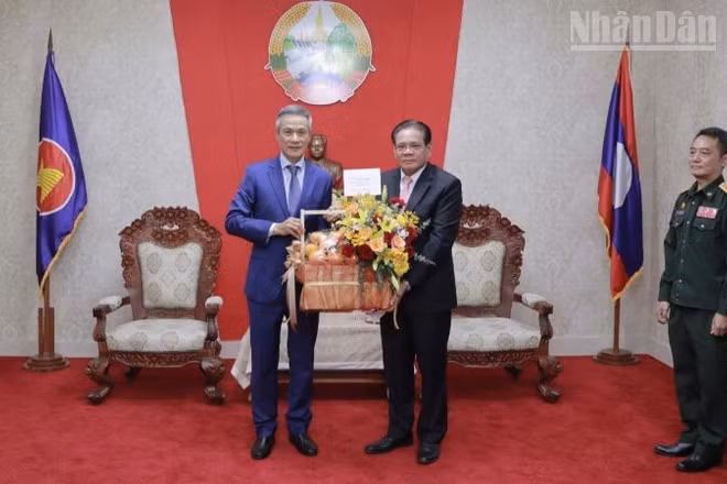 Đại sứ Nguyễn Minh Vũ (trái) chúc mừng Đại sứ Lào Buakeo Phumvongsay nhân kỷ niệm 50 năm Quốc khánh Lào. (Ảnh: Đại sứ quán Việt Nam tại Campuchia)