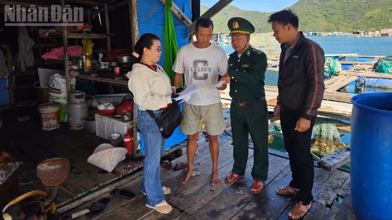 Cán bộ Đồn Biên phòng An Hải cùng các chủ phương tiện và ngư dân trao đổi, hướng dẫn kê khai, rà soát hồ sơ tàu cá tại lồng bè. (Ảnh: THÙY DUNG)