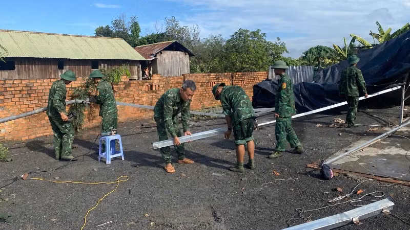 Cán bộ, chiến sĩ Đồn Biên phòng Yok Đôn và Tiểu đoàn Huấn luyện-Cơ động giúp nhân dân xã Buôn Đôn khắc phục hậu quả thiên tai.