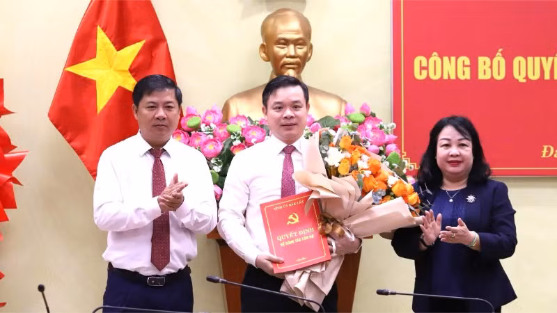 Các đồng chí Ủy viên Trung ương Đảng: Lương Nguyễn Minh Triết, Bí thư Tỉnh ủy và Cao Thị Hòa An, Phó Bí thư Thường trực Tỉnh ủy, Chủ tịch Hội đồng nhân dân tỉnh Đắk Lắk trao Quyết định của Ban Thường vụ Tỉnh ủy và tặng hoa chúc mừng đồng chí Đỗ Hữu Huy. (Ảnh: TRUNG TÂN)