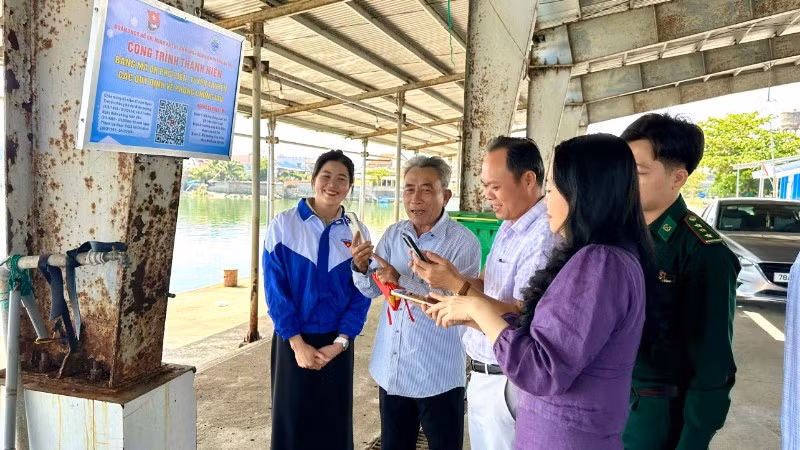 Ngư dân quét mã QR “Bảng mã QR phổ biến, tuyên truyền các quy định về phòng, chống IUU” tại cảng cá Tiên Châu.