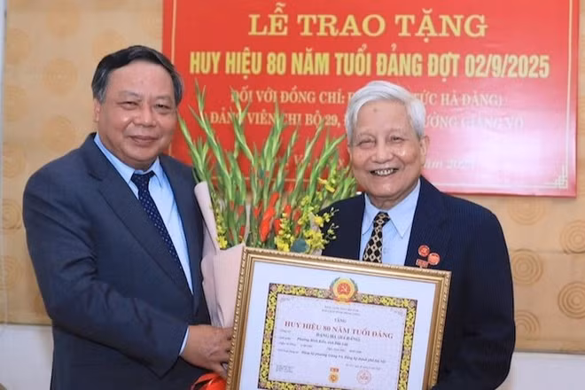 Đồng chí Nguyễn Văn Phong, Phó Bí thư Thường trực Thành ủy Hà Nội trao tặng Huy hiệu 80 năm tuổi Đảng cho nhà báo Hà Đăng. (Ảnh: Quang Thái)