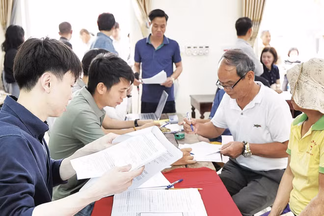 Người dân làm thủ tục nhận tiền bồi thường, hỗ trợ khi thu hồi đất phục vụ Dự án khu đô thị thể thao quốc tế Hà Nội, tại xã Tam Hưng (Hà Nội).
