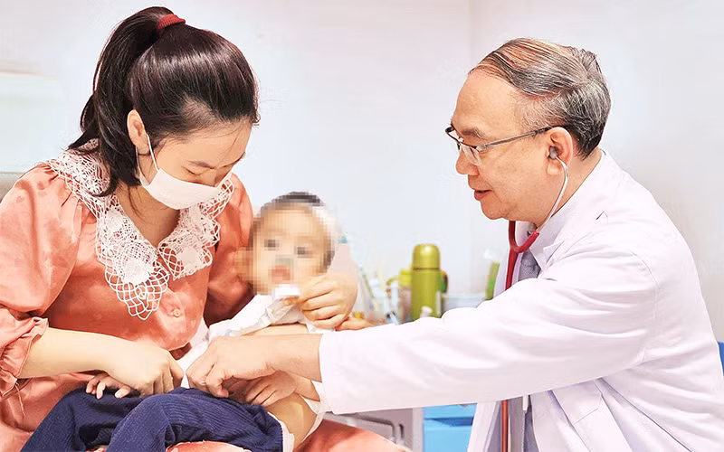 Phó Giáo sư, Tiến sĩ, Bác sĩ Vũ Chí Dũng khám cho bé Quang Thanh. 