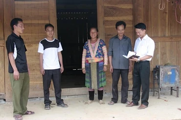 Cán bộ xã Pú Đao, huyện Nậm Nhùn vận động người dân cứng hóa nền nhà.