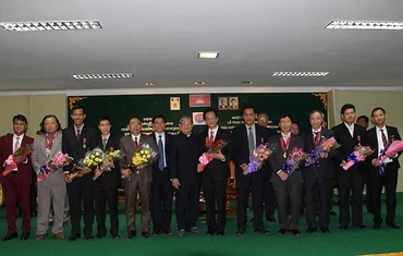 Bộ trưởng Thông tin Campuchia Khieu Kanharith chụp ảnh lưu niệm cùng các cán bộ Việt Nam được nhận Huân chương.