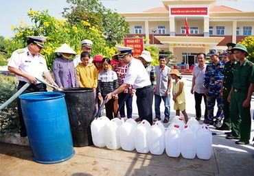Cán bộ Vùng 2 Hải quân cung cấp nước ngọt cho người dân xã Bình Thắng, huyện Bình Đại (Bến Tre). Ảnh: VÕ MINH THẮNG